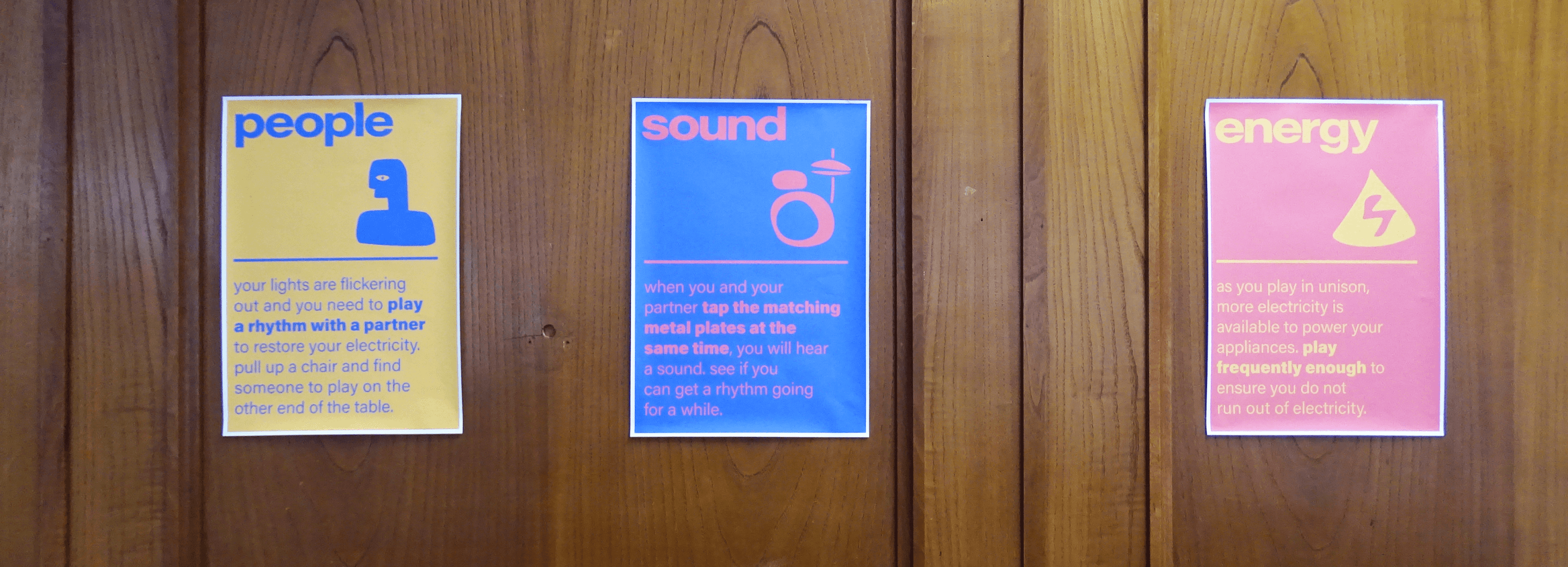 Three instruction posters titled people, sound and energy explaining how to play the drum table